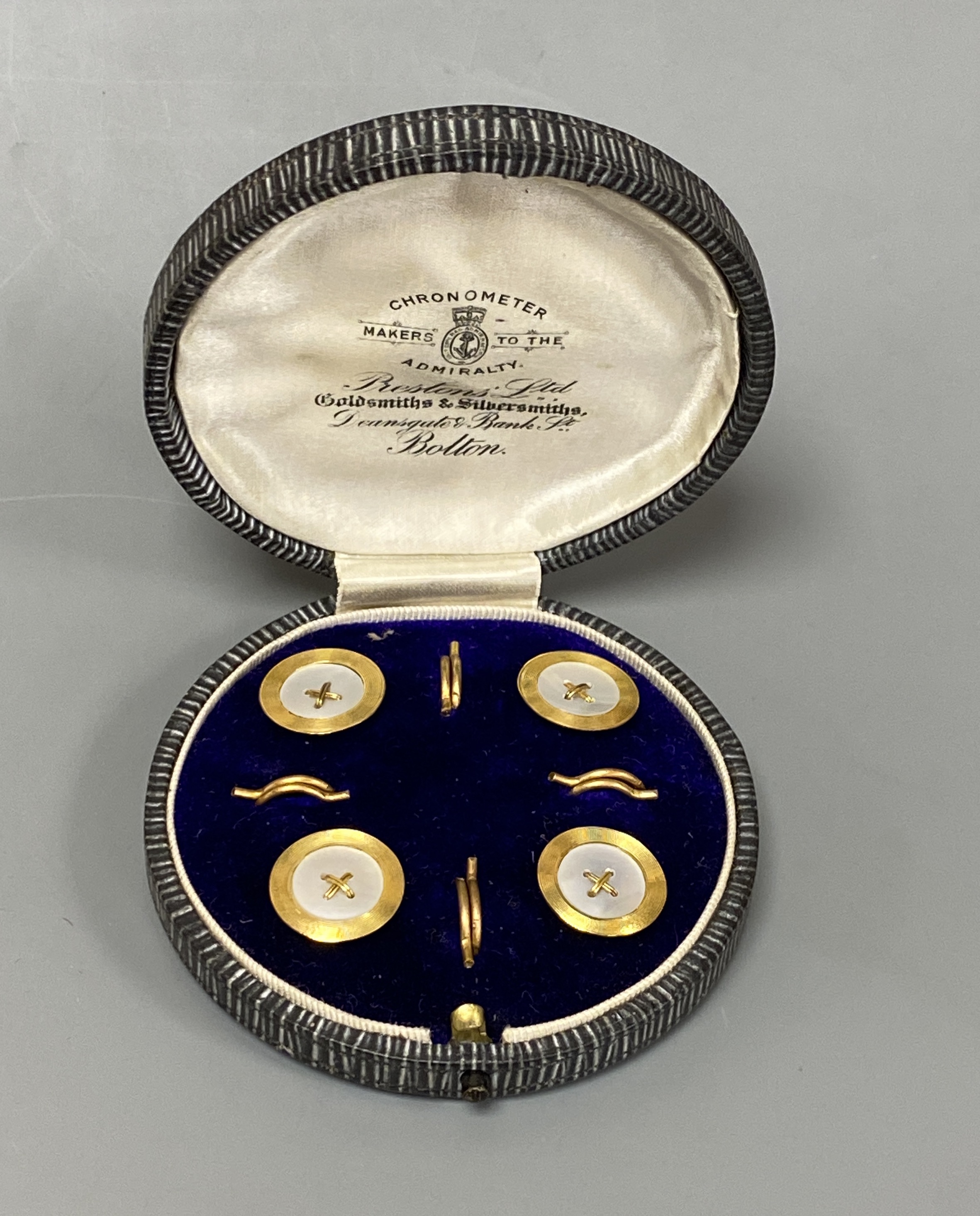 A cased set of four early 20th century 9ct and mother of pearl set buttons